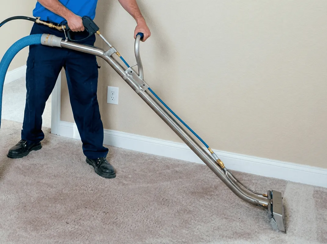 Professional operating a liquid removal machine on a carpeted floor in Sacramento, CA